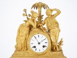 a gold clock with a statue on top of it