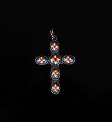 un pendentif en forme de croix bleue et rouge sur fond noir