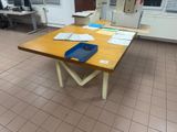 a wooden table with papers and a cell phone on it