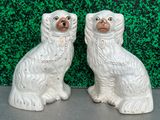 paire de figurines de chiens en céramique blanche, avec des chaînes autour du cou
