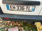 a white car that has a blue license plate on it