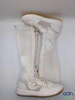 une paire de bottes blanches accrochées au mur