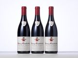 three bottles of red wine sitting on top of a table