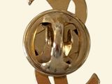a gold pin with a face on it that says y