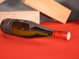 a bottle of wine sitting on a table next to a wooden box