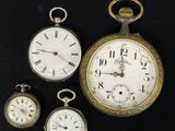 Quatre types différents de montres de poche sont exposés sur un fond noir