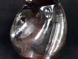 a glass vase with a horse head on it on a black background