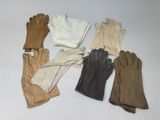 cinq paires de gants empilées les unes sur les autres sur une table