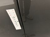 a man standing in front of a refrigerator with a ruler on the door