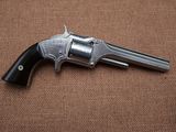 a close up of a revolver on a brown background