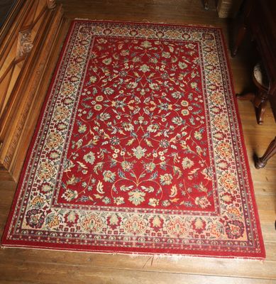a close up of a red rug on a wooden floor