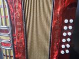 a close up of a red accordion sitting on top of a table
