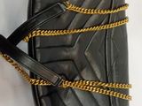 a black purse with gold chains on a white background