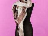 une écharpe posée sur un mannequin, sur fond rose