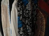 a lot of clothes hanging on a rack in a closet