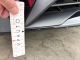 a person holding a ruler in front of a car