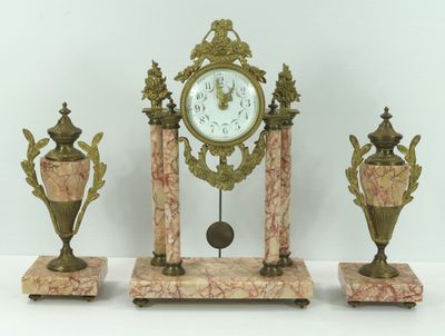 une horloge et trois vases posés sur une table