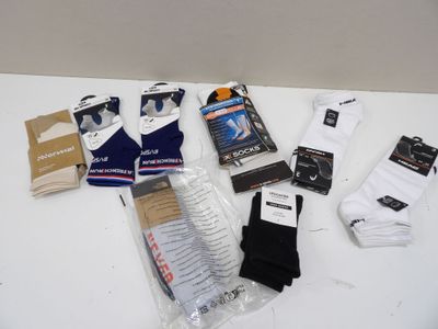 Plusieurs paires de chaussettes blanches pour homme sont posées sur une table