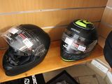 two helmets sitting on a shelf in the corner of a room