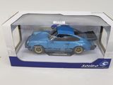 La petite voiture bleue se trouve dans la boîte posée sur la table.