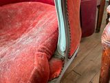 a red chair that is sitting on a wooden floor