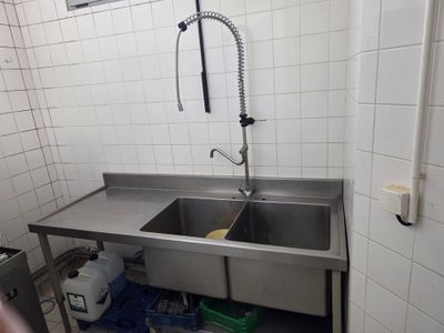 a stainless steel sink in the corner of a kitchen