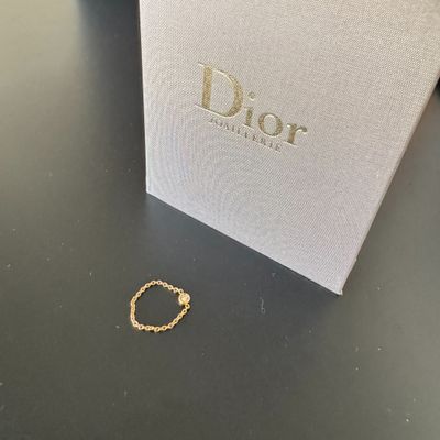 une bague en or est posée sur une table, à côté d'une boîte blanche