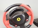 ferrari steering wheel with red and black spokes next to a remote control