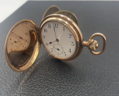 une montre de poche en or posée sur une table
