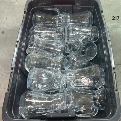de nombreuses bouteilles vides dans un bac en plastique posé par terre