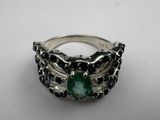 a close up of a ring with a green stone on it