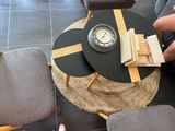 a person sitting at a table with a clock on top of it