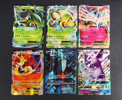 Des cartes Pokémon sont alignées sur une surface noire