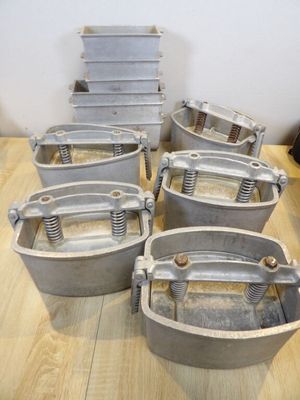 six large metal buckets sitting on top of a wooden table
