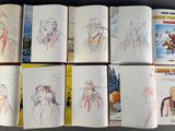 six books with drawings of people on them sitting on a table