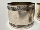 a silver cup sitting next to a silver cup on a table