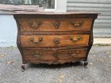 commode ancienne sur roulettes devant un immeuble