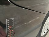 someone is measuring the height of a car ' s tire with a ruler
