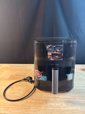 un gros plan sur une cafetière noire posée sur une table en bois