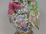 deux figurines posées sur un vase