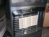a black heater sitting on the floor next to a cardboard box