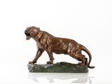 statue en bronze représentant un lion posé sur un rocher, sur un fond blanc