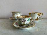 three cups and saucers sitting on a marble table