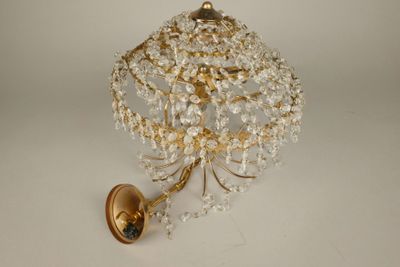 une applique murale dorée ornée d'une boule de cristal