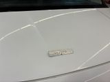 a close up of a white car with a sticker on the hood