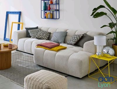 un salon avec un canapé blanc et une table basse jaune