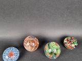 four different colored marbles sitting on top of a black surface