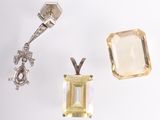 an image of a pair of earrings and a pendant on a white surface
