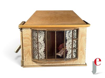 a small doll sitting in a doll house made out of wood