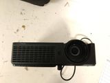 a small projector sitting on a table next to a cell phone